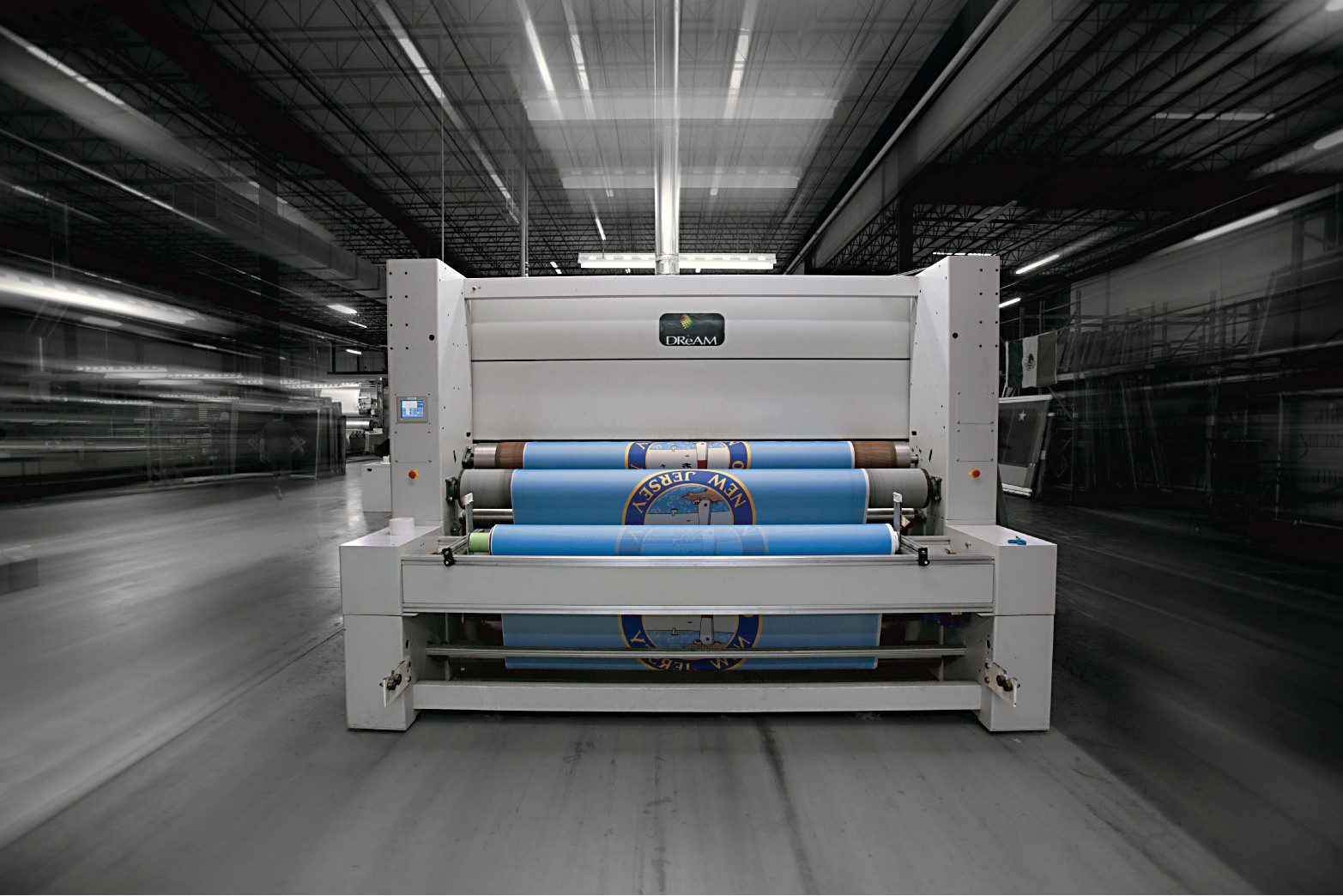 Large industrial fabric printing machine in motion.